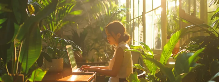 a woman typing on a laptop in a serene, sunlit room with lush green plants surrounding her, reflecting a focus on enhancing seo impact through regular content updates.