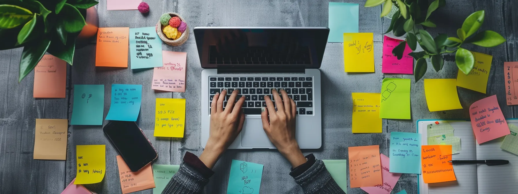 a person typing on a laptop surrounded by sticky notes filled with long-tail and question-based keywords, highlighting the focus on voice search optimization.