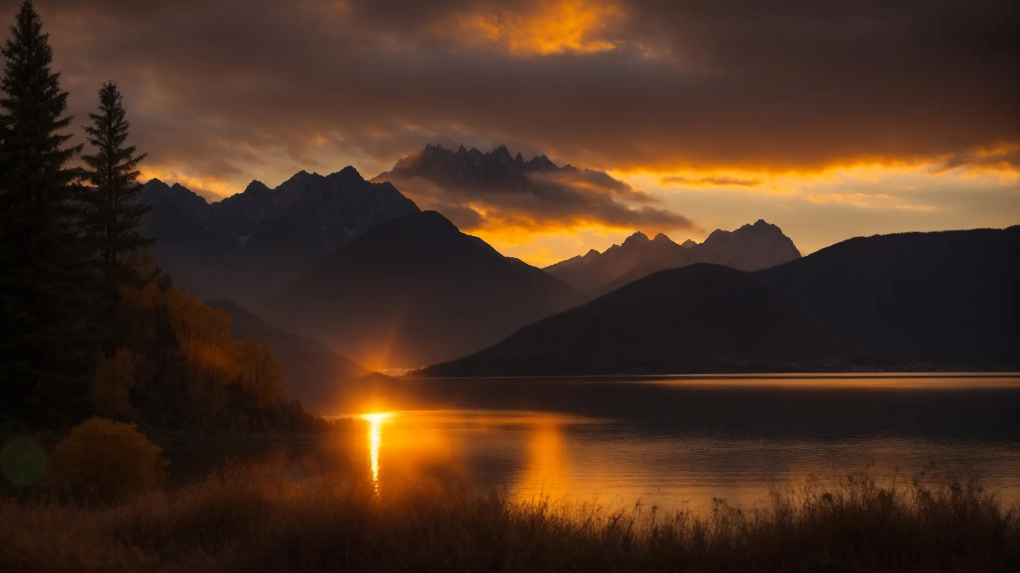 a vibrant sunset casts a warm golden glow over a serene lake, with silhouetted mountains rising majestically in the background.