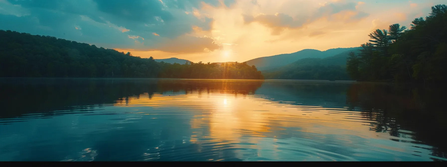 a vibrant sunset casts golden hues across a tranquil lake, reflecting the surrounding mountains and towering evergreens bathed in warm light.